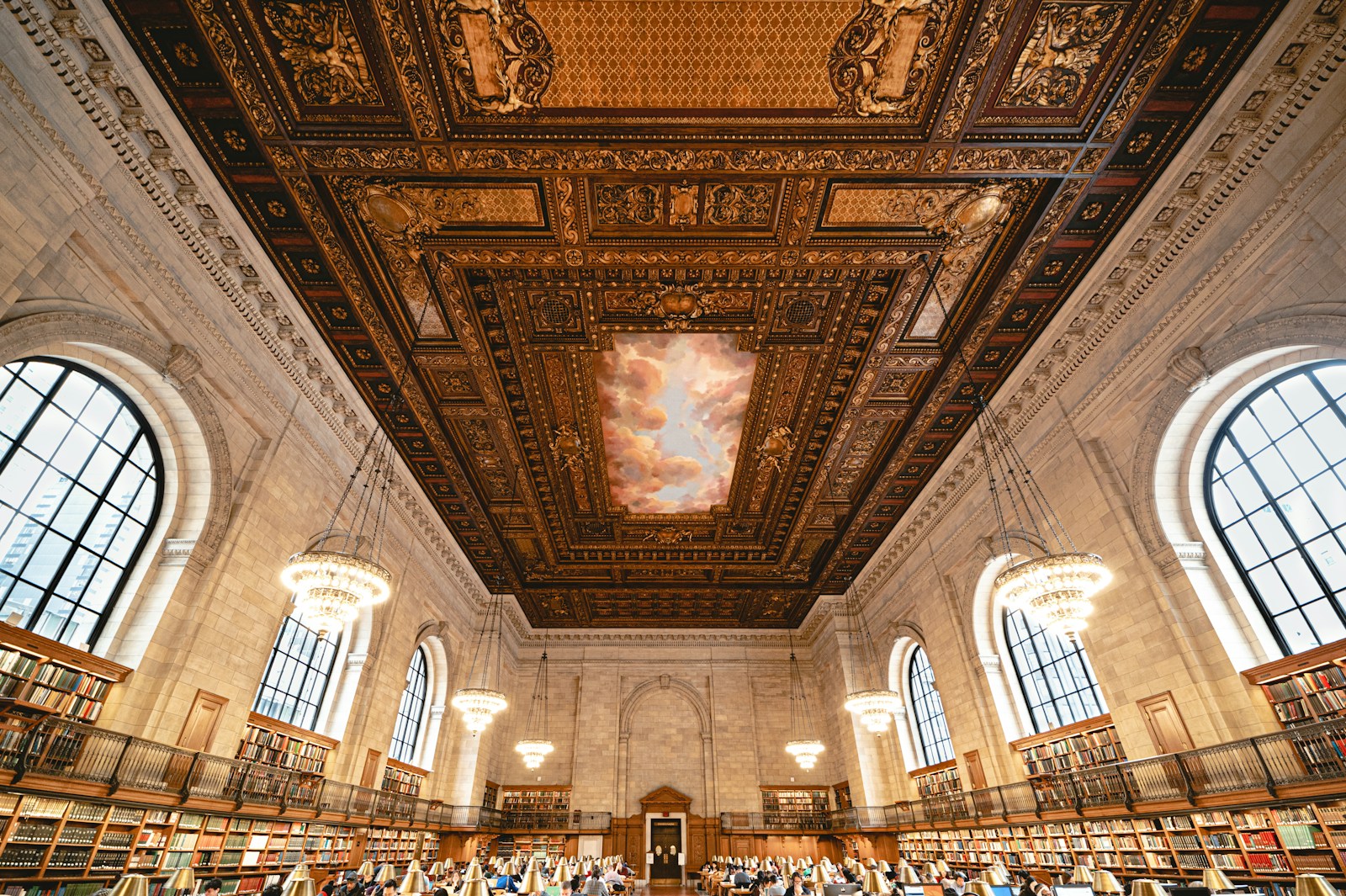 A quiet reading room with wooden desks and warm lamplight, an empty chair pulled up to an open notebook
